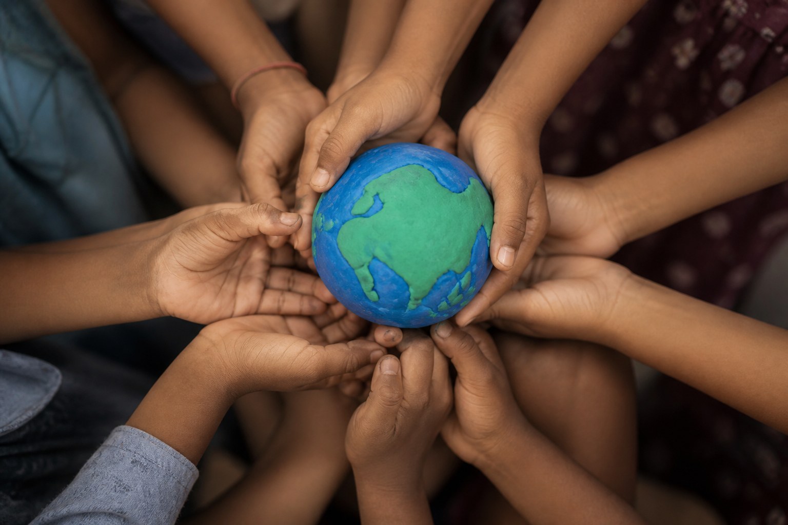 Children holding a handmade globe together